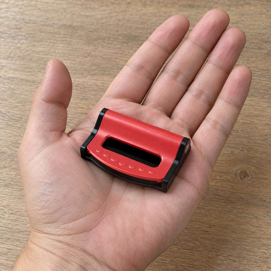 One red BeltEase clip shown in an adult hand for scale