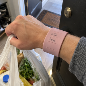 Pink memo band wrapped around the wrist during everyday grocery carry