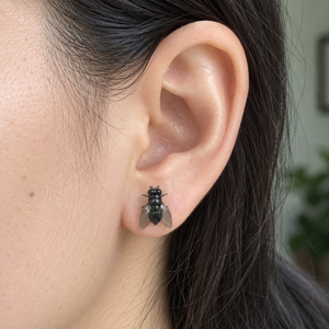 Buzzkill Large fly stud earring worn on an earlobe