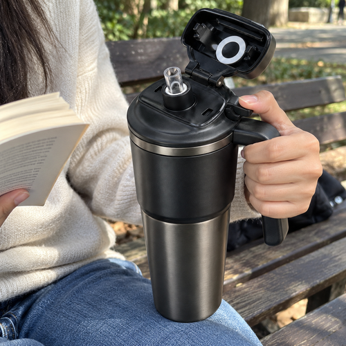Hand using the side release with flip lid open and drinking spout visible
